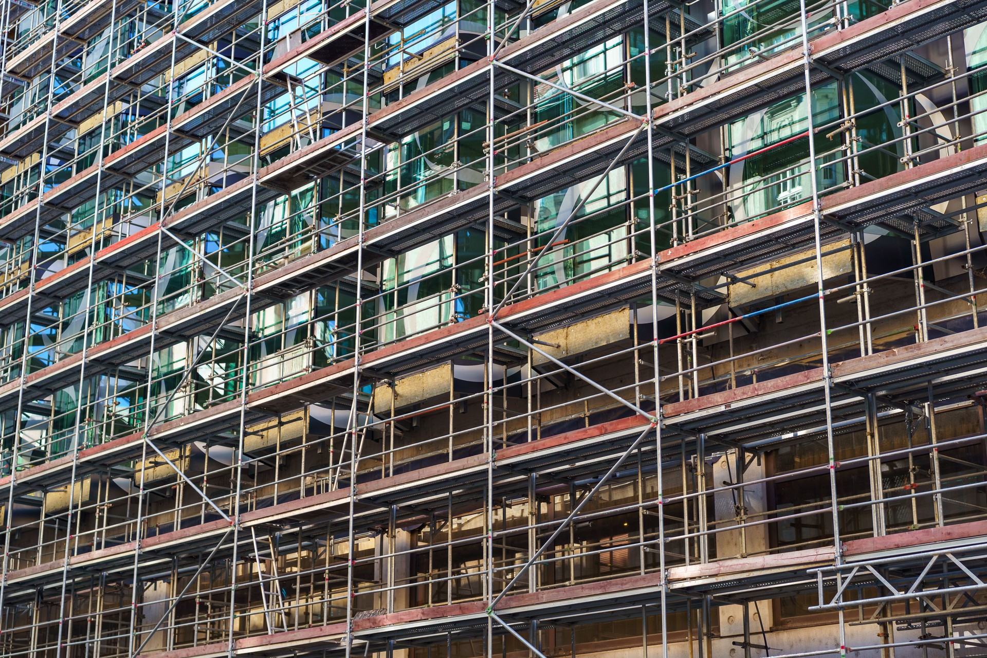 Un bâtiment moderne recouvert d’échafaudages lors de la rénovation et du nettoyage.