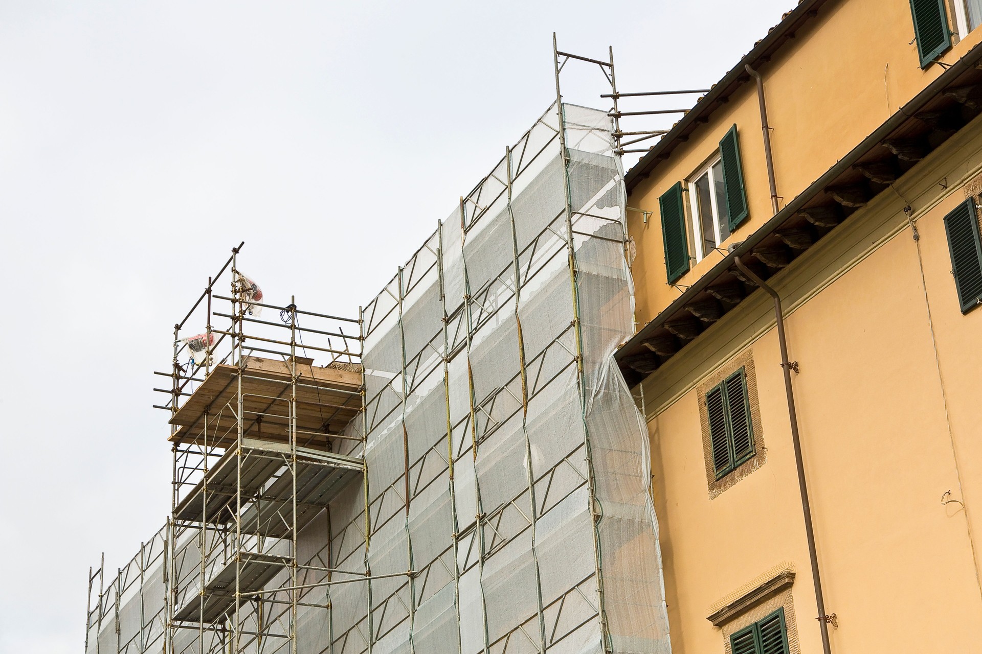 Metal scaffolding on a construction site built with prefabricated components to work safely on the facade of a building for the renovation of the plaster wall or realization of thermal insulation to improve the energy efficiency of the building